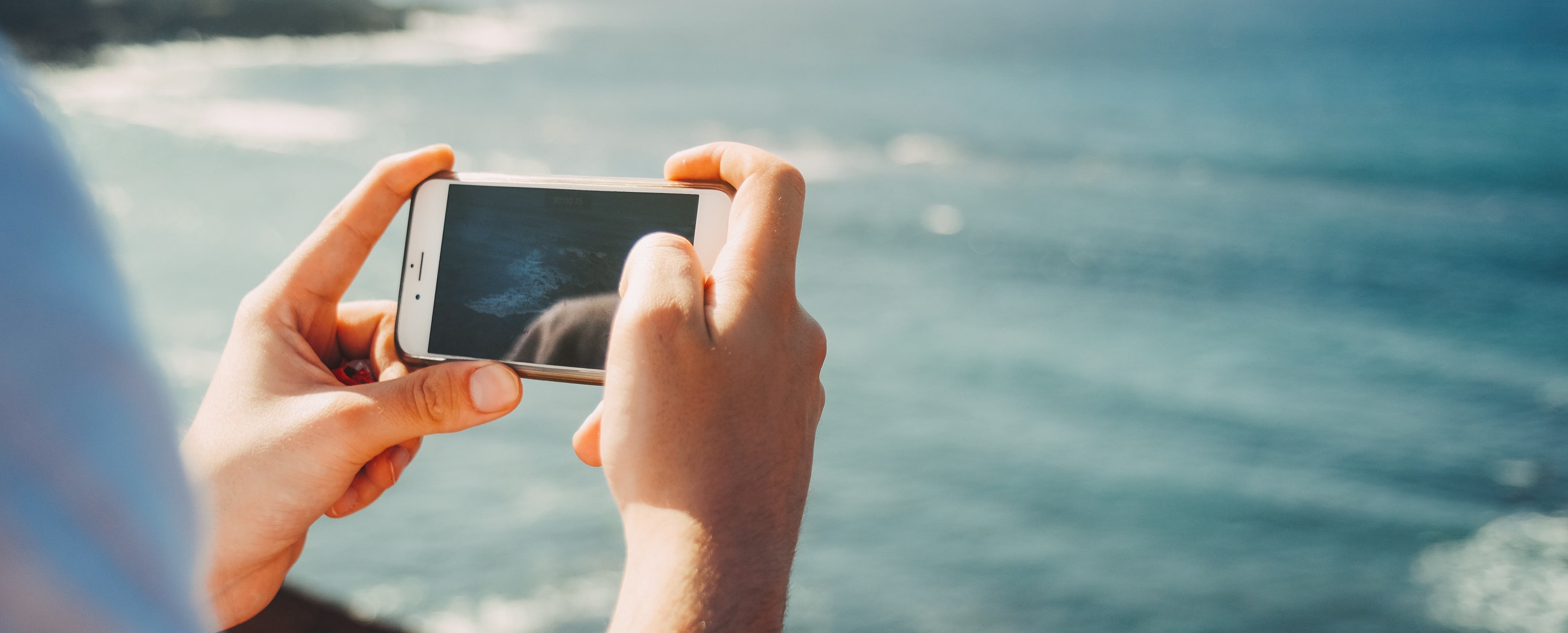 море на смартфон. оригинальное мужское селфи. красиво фотографировать. телефон в руке. Iphone в воздухе.