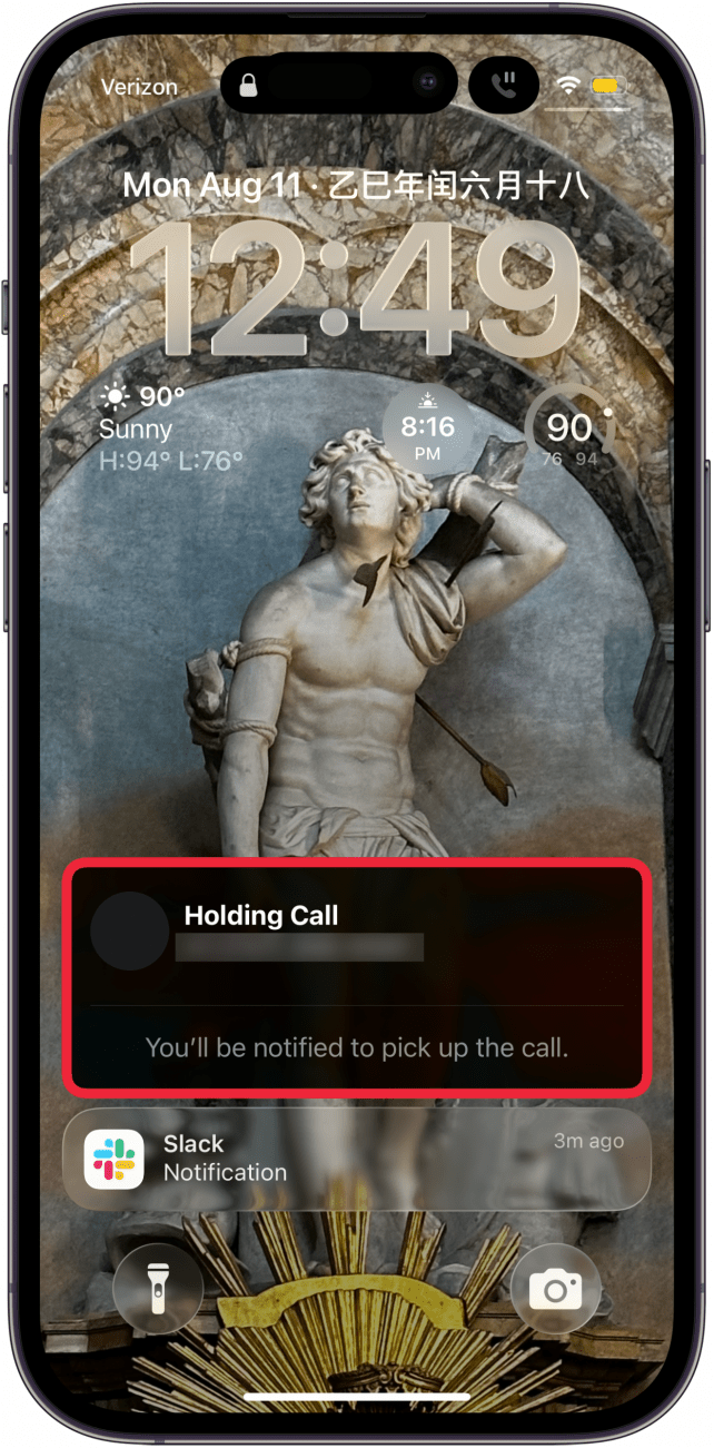 a screenshot of an iphone lock screen with a notification that the call is being held