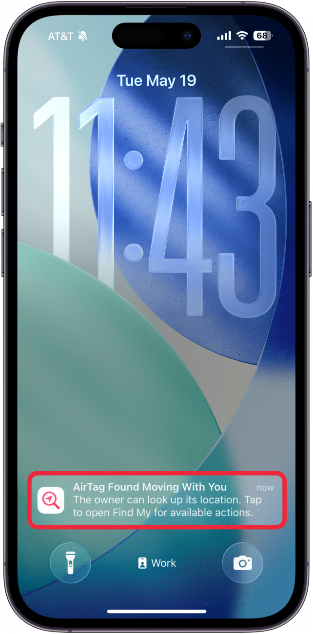 a screenshot of the iphone lock screen with a red box around a notification that says an airtag has been detected moving withh you