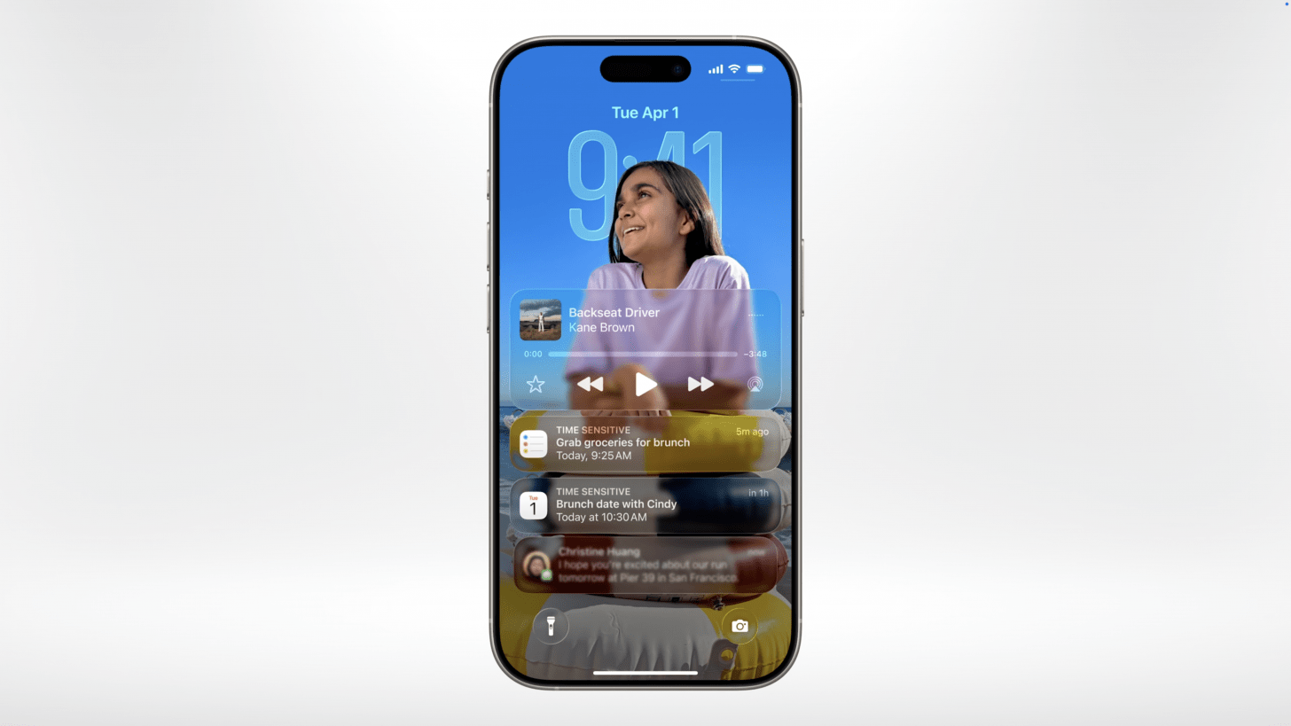 screenshot of an iPhone lock screen on iOS 26 showing music playing and notifications coming in