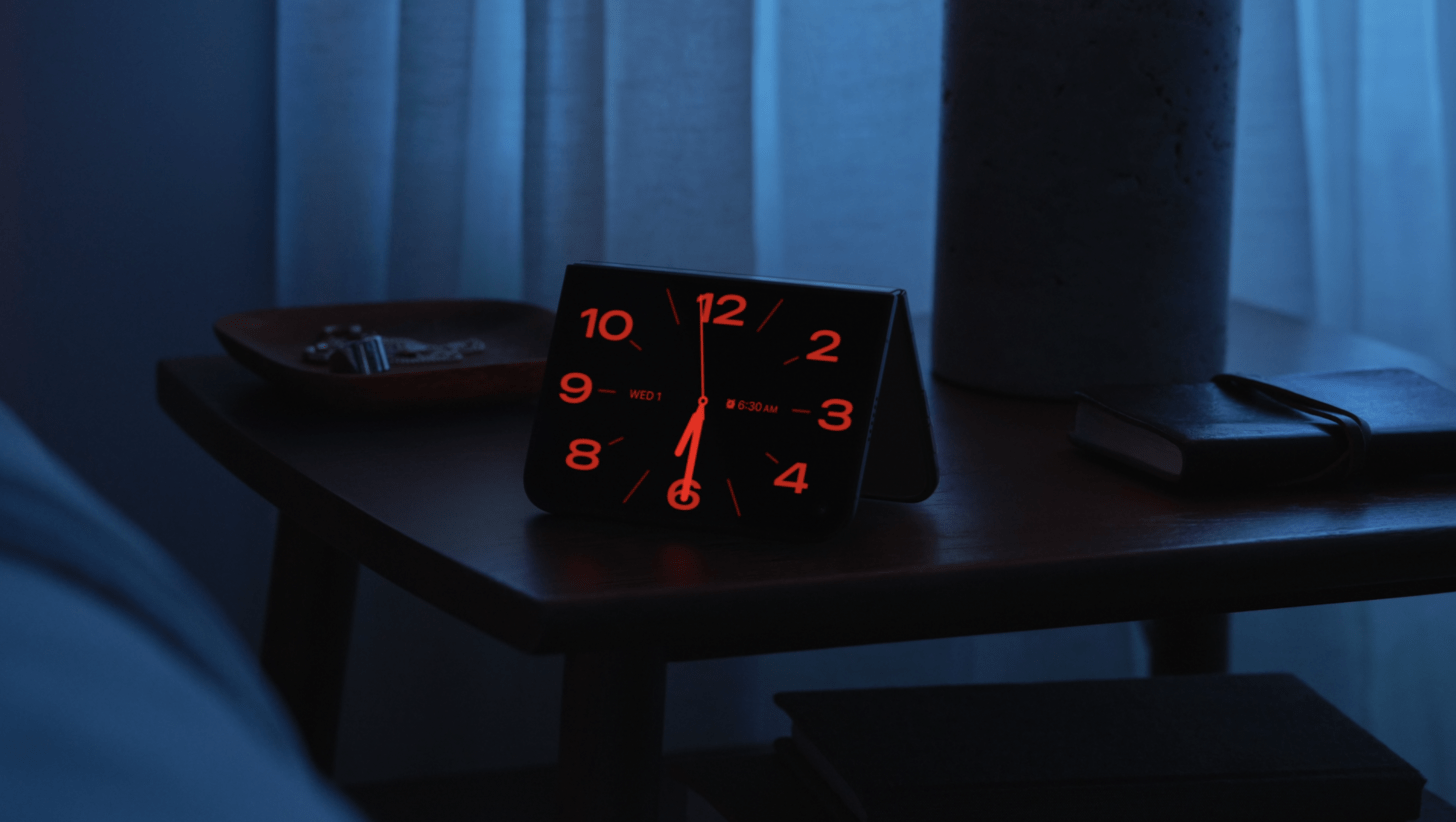 an image showing an iphone duo in the standing configuration displaying a red toned bedside clock
