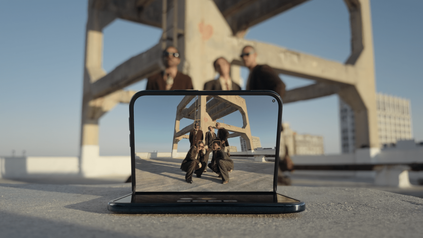 an image showing an iphone duo in the sitting configuration while a group of friends pose for camera