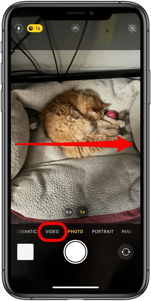 Camera app in Photo mode with the Video mode button marked and a an arrow from the left to the right of the screen.