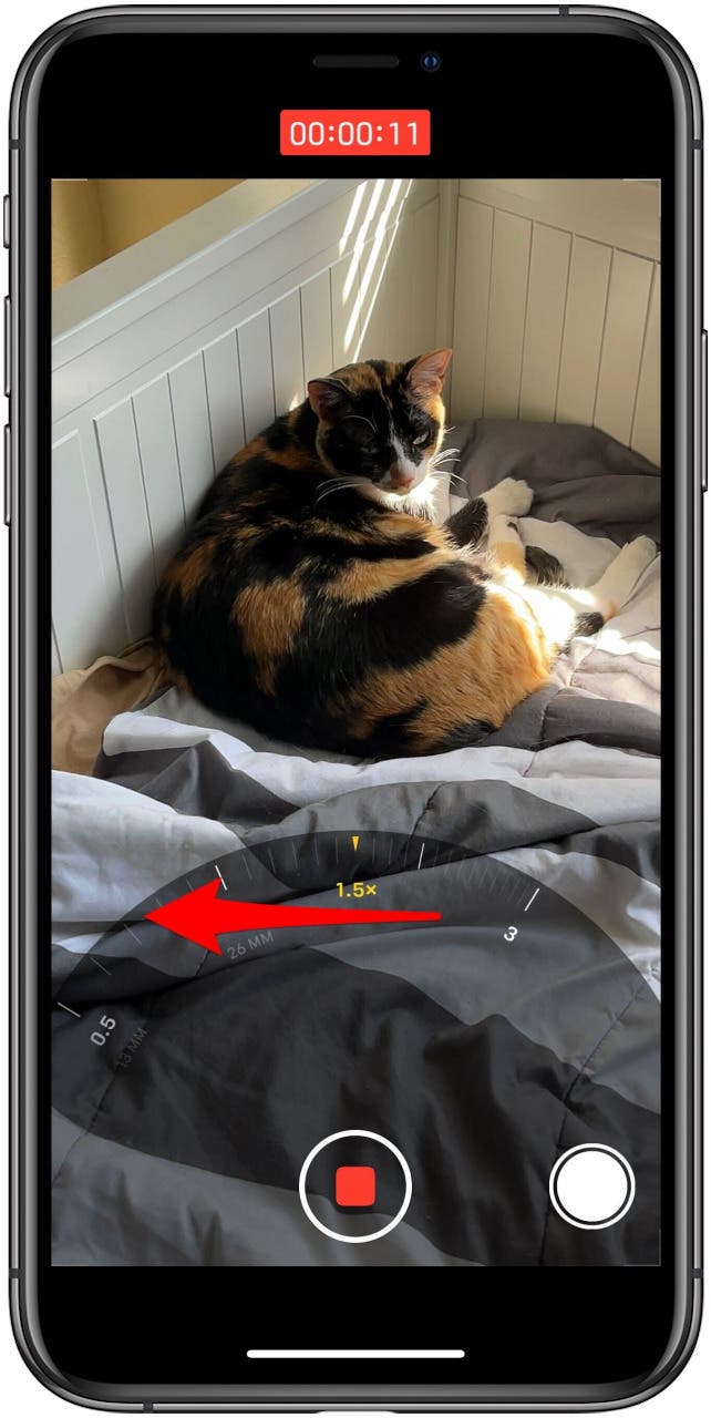 Camera app in Video mode, while recording, with the zoom wheel visible and a marking indicating swiping the wheel to zoom.
